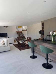a living room with two green chairs and a table at Sotogrande Polo Experience Luxury Villa in Sotogrande