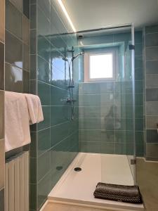 a bathroom with a shower with green tiles at Les Rochers in Saint-Savin +116 photos