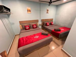 two beds in a room with red pillows at Hotel Yasmin in Brinchang +18 photos