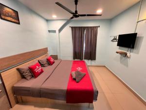 a bedroom with a bed with a red blanket at Hotel Yasmin in Brinchang