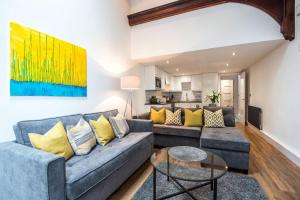 a living room with a blue couch and yellow pillows at Fifty Two Old Elvet in Durham
