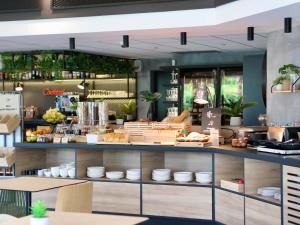 a restaurant with a counter with dishes on it at ibis Aubenas in Aubenas