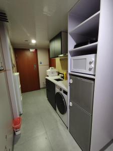 a small kitchen with a stove and a microwave at Ocean Inn in Hong Kong
