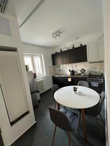 a kitchen with a white table and chairs in a room at Sweet Escape Pécs in Pécs