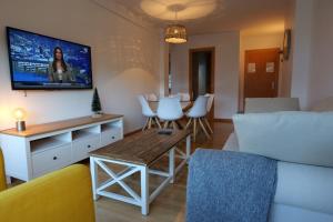 a living room with a couch and a tv on the wall at Soldeu Paradis Clos in Soldeu