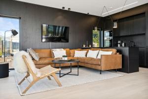 a living room with a couch and a table at Lyngvær Arctic Pearl Lodge - Jacuzzi & Sauna - No 17 in Kleppstad