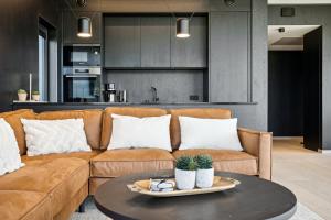a living room with a couch and a table at Lyngvær Arctic Pearl Lodge - Jacuzzi & Sauna - No 17 in Kleppstad