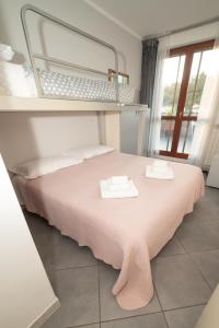 a bedroom with a pink bed with two towels on it at L'attico Rinascente in Signa