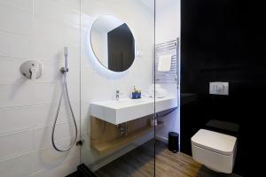 a bathroom with a sink and a mirror and a toilet at KVi Hotel Budapest - the smart hotel in Budapest
