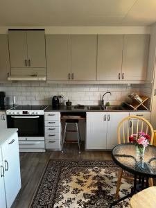 a kitchen with white cabinets and a table and a sink at Spacious house in cozy Kristdala in Kristdala