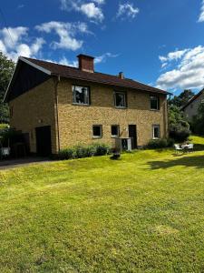 a large brick house with a large grass yard at Spacious house in cozy Kristdala in Kristdala