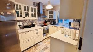a kitchen with white cabinets and a stainless steel refrigerator at Çeşme Seaside House in Çeşme
