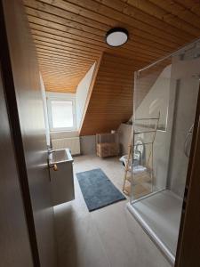 a attic room with a ladder and a room with a ceiling at Ferienwohnung Bergblick Bad Staffelstein in Bad Staffelstein