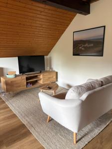 a living room with a couch and a television at Ferienwohnung Bergblick Bad Staffelstein in Bad Staffelstein