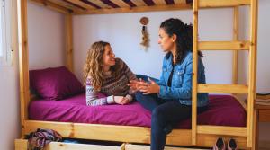 two women sitting on a bunk bed at Ira Hostel in Dahab