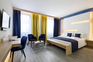 a bedroom with a bed and a desk with a computer at KVi Hotel Budapest - the smart hotel in Budapest