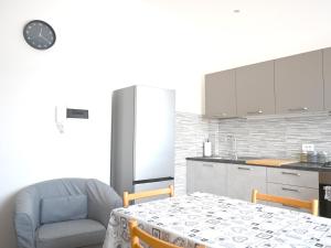 a kitchen with a table and a chair and a refrigerator at SE268 - Marzocca, comodo quadrilocale con garage in Marzocca di Senigallia