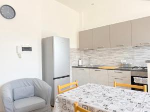 a kitchen with a table and a chair and a refrigerator at SE268 - Marzocca, comodo quadrilocale con garage in Marzocca di Senigallia +19 photos