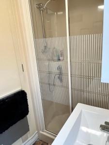 a bathroom with a shower and a white sink at Willows Retreat in Reighton +8 photos