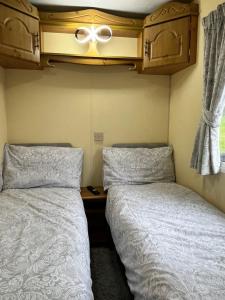 two beds sitting next to each other in a room at Willows Retreat in Reighton
