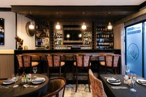 a restaurant with tables and chairs and a bar at Sasavona Boutique Hotel in Polokwane