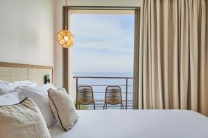 a bedroom with a bed and a view of the ocean at Les Roches Brunes in Collioure