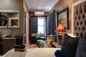 a hotel room with a bed and a living room at Sasavona Boutique Hotel in Polokwane