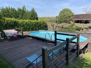 a swimming pool on a wooden deck next to at Clos Suzette - Gîte de groupe - Maison de vacances - Kirrwiller in Kirrwiller