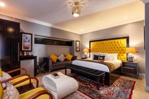 a bedroom with a large bed and a couch at Sasavona Boutique Hotel in Polokwane