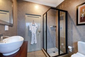 a bathroom with a sink and a glass shower at Sasavona Boutique Hotel in Polokwane +92 photos