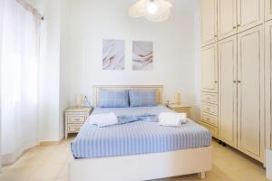 a white bedroom with a bed and two towels on it at Thalassini in Daratso