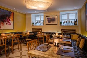 ein Restaurant mit Holztischen und -stühlen und Fenstern in der Unterkunft My City Hotel in Tallinn