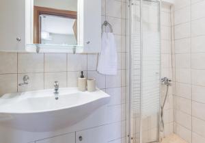 a white bathroom with a sink and a shower at Thalassini in Daratso +37 photos