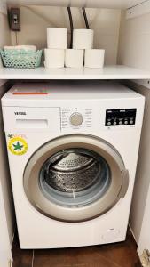 a white washing machine with dishes on a shelf at Çeşme Seaside House in Çeşme