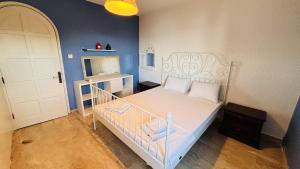 a small bedroom with a bed with a white crib at Çeşme Seaside House in Çeşme