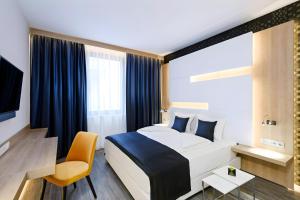 a hotel room with a bed and a chair at KVi Hotel Budapest - the smart hotel in Budapest