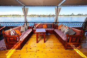 a living room with couches and a view of the water at Dahabiya Queen Tyi II in Luxor
