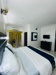 a large white bed in a bedroom with a television at Unique luxury duplex in Lekki