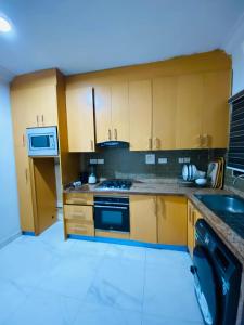 a kitchen with wooden cabinets and a stove top oven at Unique luxury duplex in Lekki +9 photos