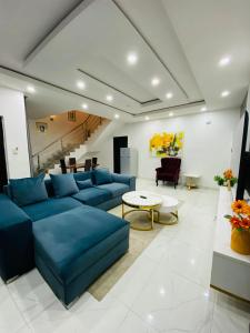 a living room with a blue couch and a table at Unique luxury duplex in Lekki