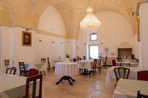 a dining room with tables and chairs and a chandelier at Dimora Mennuti in Monteparano