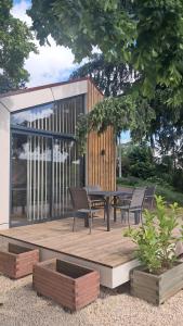 a wooden deck with a table and chairs on it at Chalet Villerest in Villerest
