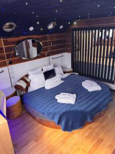 a bedroom with a bed with a blue comforter and a mirror at Mała Anglia Deluxe Rooms & SPA in Sopot