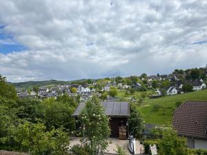 a view of a small town with houses on a hill at Ferienwohnung Auszeit am Waldrand in Olpe +7 photos
