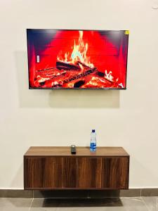 ein Flachbildfernseher an der Wand neben einem Kamin in der Unterkunft Screenshot Hotel in Mtwapa