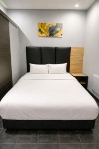 a bedroom with a large white bed in a room at Hotel Metro Lodge Xpress in Durban +7 photos