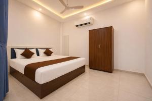 a bedroom with a bed and a wooden cabinet at Shree Sita Sadan in Ayodhya