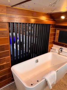 a bath tub in a bathroom with wooden walls at Mała Anglia Deluxe Rooms & SPA in Sopot