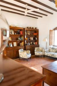 a living room with two chairs and a book shelf at Cortijo El Solano in Antequera