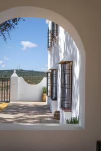 an external view of a white building with an archway at Cortijo El Solano in Antequera